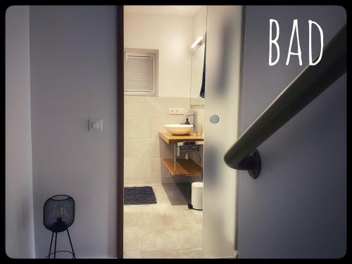 a door leading to a bathroom with a bad sign at Gemütliches Apartment mit Moselblick in Reil
