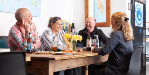 a group of people sitting around a wooden table at Ocean Backpackers self-catering hostel in Ilfracombe