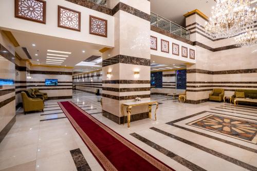 a lobby of a hotel with a table and chairs at Snood Al Dana Hotel in Makkah