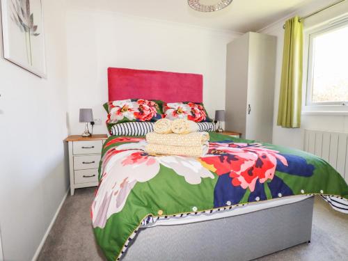 a bedroom with a large bed with a colorful bedspread at Hunrosa in Redruth