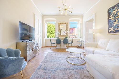 a living room with a white couch and a table at James Joyce Luxury Apartment in Trieste