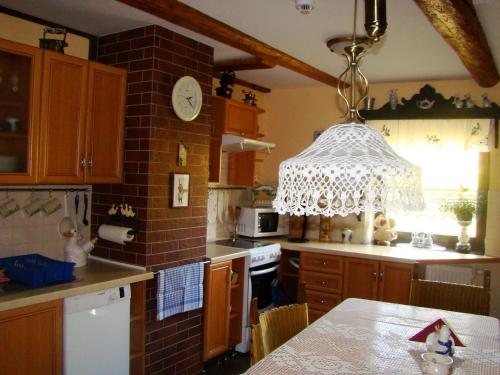 a kitchen with a chandelier hanging over a table at Agroturystyka Łysa Góra in Jelenia Góra