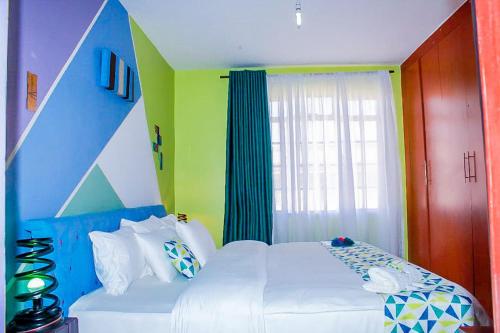 a bedroom with a white bed and a window at Cozy Rooms -JKIA in Syokimau