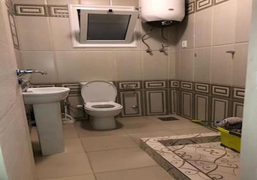 een badkamer met een toilet, een wastafel en een tv bij Modern 3 Bedroom Apartment Walk to Cafés & Bookstores in Caïro