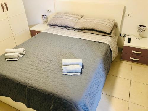 a bedroom with a bed with towels on it at Little dream & relax Fiera di Roma in Ponte Galeria