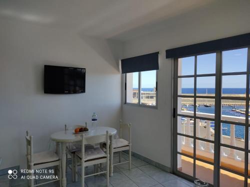 uma sala de jantar com uma mesa e uma televisão na parede em Apartamento Puerto de la Estaca 1 em Valverde