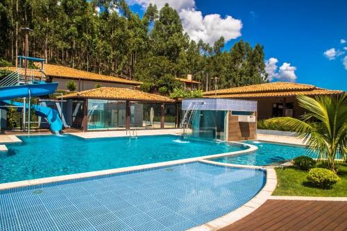 a swimming pool with a water slide in a house at A Fazenda eventos e lazer Lindomar Gonçalves in Piumhi
