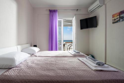 a hotel room with two beds and a window at mansion luxury apartment in Psakoudia