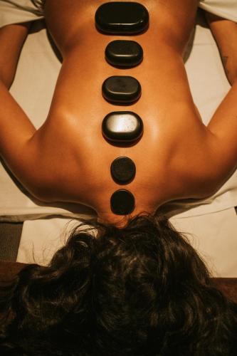 a woman laying on a bed with buttons on her back at Sweet Atlantic Hotel & Spa in Figueira da Foz