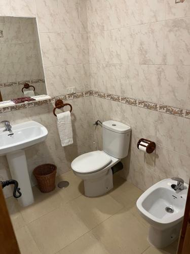 a bathroom with a white toilet and a sink at Hostal Ciudad Encantada in Cuenca