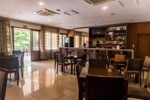 a restaurant with tables and chairs and a bar at Hotel Nacional Inn Araxá Previdência in Araxá
