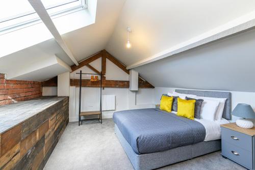 a bedroom with a bed and a brick wall at Carriage Works Apartments in Preston in Preston
