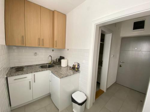 a small kitchen with white cabinets and a sink at Apartment 13 in Vrnjačka Banja