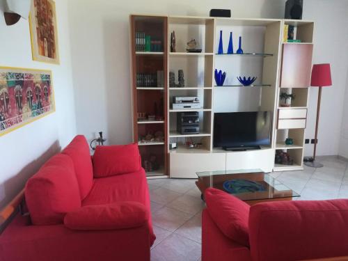 sala de estar con sofá rojo y TV en CASA T.U.A. en Sale Marasino