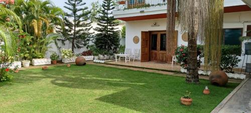 a yard of a house with a lawn with plants at Villa Ekabo in Cotonou