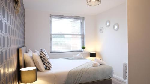 a white bedroom with a bed and a window at Contractors&Leisure - Bedford Hospital & City Centre inc Private Parking in Bedford