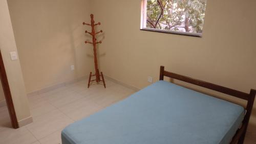 Praia de Setiba - Kitnet في غواراباري: غرفة نوم صغيرة بها سرير ونافذة صغيرة