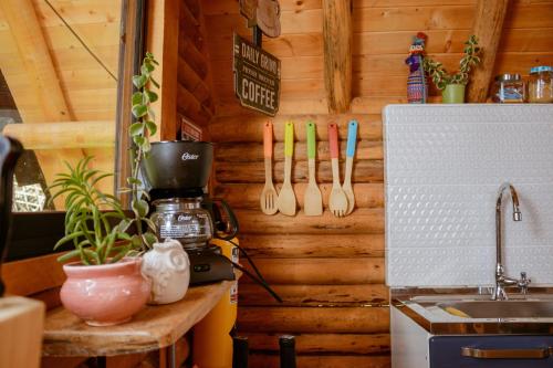 a kitchen with wooden walls and a counter with utensils at BRUMA BLANCA CHALETS in Medellín