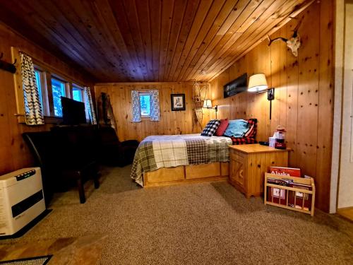 a bedroom with a bed in a wooden room at Northwoods Cottage Bed and Breakfast in Fairbanks