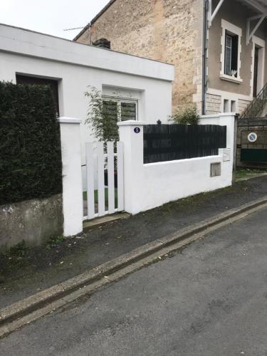 une clôture blanche devant une maison dans l'établissement Charmante maison de ville, à Périgueux