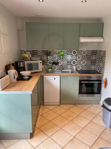 une cuisine avec un évier et un micro-ondes dans l'établissement La charetterie, à Canouville