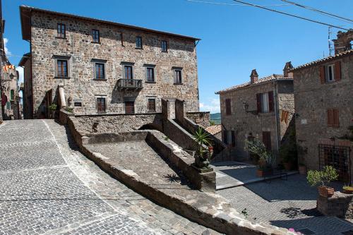 um antigo edifício de pedra com escadas em frente em The view with a room em Bolsena