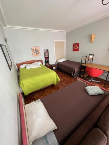 een woonkamer met 2 bedden en een bank bij Hostal del Cerro in Santiago
