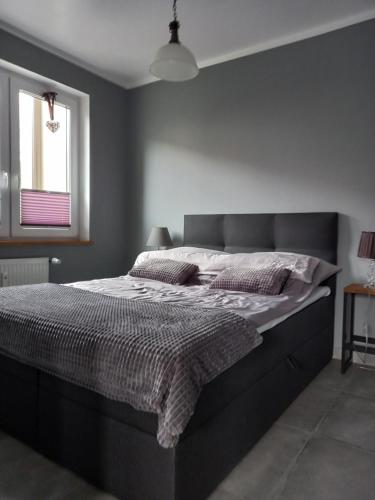 a large bed in a bedroom with a window at Apartament Marco in Koszalin