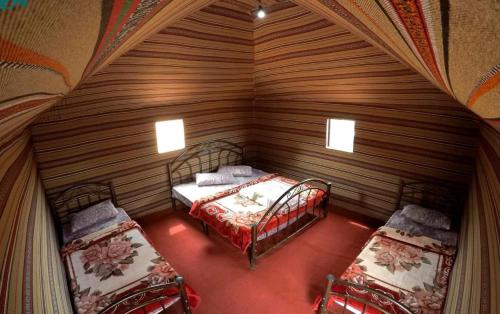 Habitación pequeña con 2 camas en una habitación de madera en Salem Camp en Wadi Rum