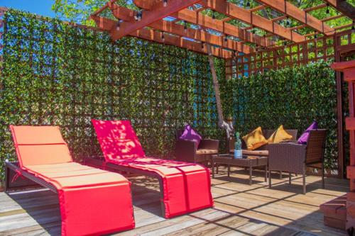 a patio with chairs and tables and a green wall at Hotel and Dive Center Roatan Yacht Club in Roatán