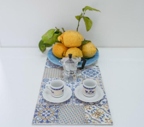 a table with two cups and a tea set on it at La casa del postino in Procida