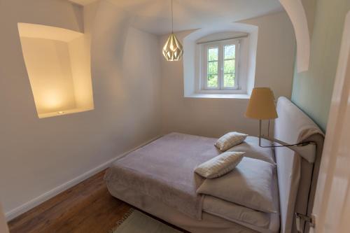a small bedroom with a bed and a window at Ferien- und Pferdegut Schloss Treffen in Görtschach