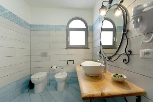 a bathroom with a sink and a toilet and a mirror at La casa del postino in Procida