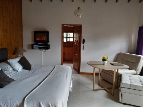 a bedroom with a bed and a table and a couch at Hotel Gran Boutique Sabana in Chía