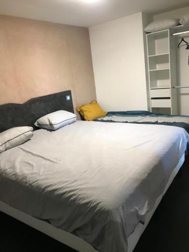 ein Schlafzimmer mit einem großen weißen Bett mit zwei Kissen in der Unterkunft Résidence bord de Loire route euro 6 in Decize