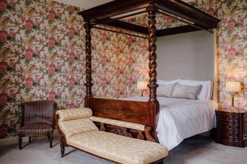 ein Schlafzimmer mit einem Himmelbett und einem Stuhl in der Unterkunft Noan Country House B&B in Cashel