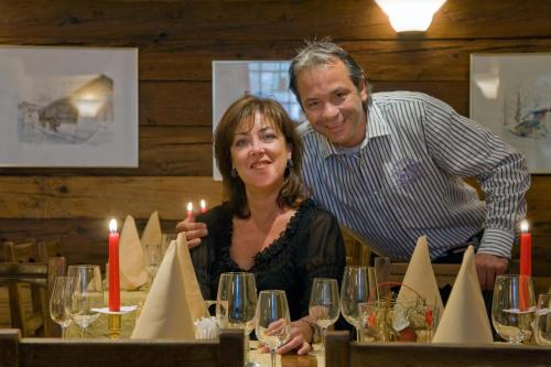 a man and a woman sitting at a table with wine glasses at Hotel Römerhof in Leukerbad