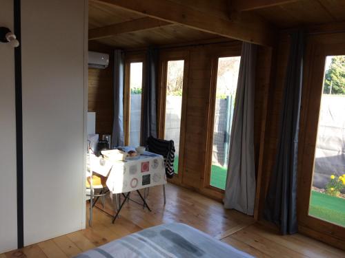 a room with a table and some windows at Chalet piscine montech in Montech