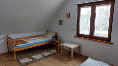 Habitación pequeña con cama y ventana en Dom nad doliną Sanu, en Ruszelczyce