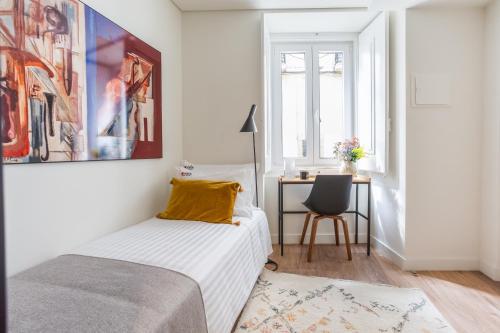 una camera con letto e scrivania con sedia di Bairro Alto Music Guest House a Lisbona