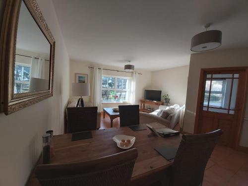 a living room with a wooden table and a mirror at Shanakeever Farm - 2 Bedroom Apartment in Clifden