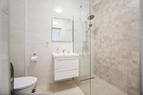 un bagno bianco con lavandino e doccia di Trio Pink a Oradea