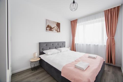 una camera da letto con un letto grande con una coperta rosa di Trio Pink a Oradea