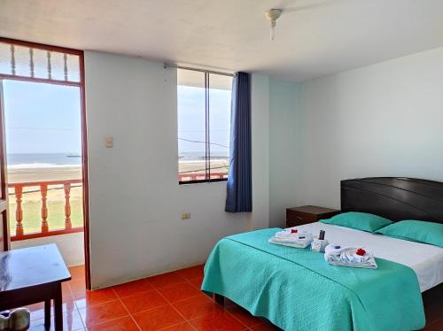 a bedroom with a bed with a view of the ocean at Hotel Nuevo Amanecer Malabrigo in Puerto Chicama