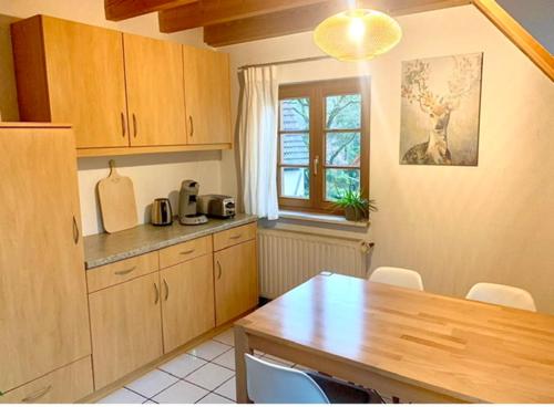 cocina con armarios de madera, mesa y ventana en Ferienwohnung Diana, en Sexau