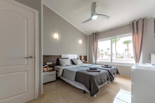 sypialnia z łóżkiem i wentylatorem sufitowym w obiekcie La Rosa de los vientos luxury apartment w Adeje