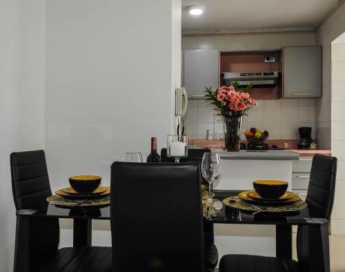 a kitchen with a dining room table with two chairs at Hermoso Apartamento Central in Pereira