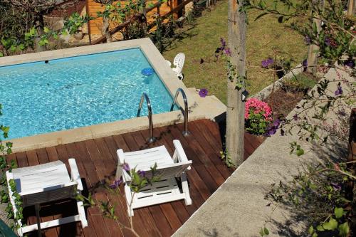 an overhead view of a swimming pool with two chairs and a table at Casas D'Aldeia Arcos de Valdevez in Arcos de Valdevez