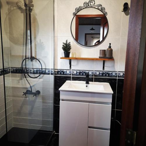 a bathroom with a sink and a mirror at Casas D'Aldeia Arcos de Valdevez in Arcos de Valdevez