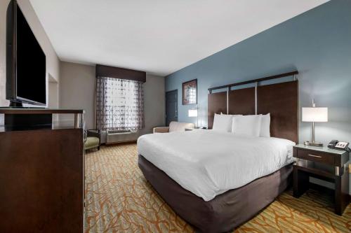 a hotel room with a large bed and a flat screen tv at Best Western Plus Bradenton Gateway Hotel in Bradenton